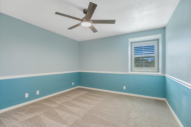 empty room with ceiling fan, a textured ceiling, baseboards, and carpet floors