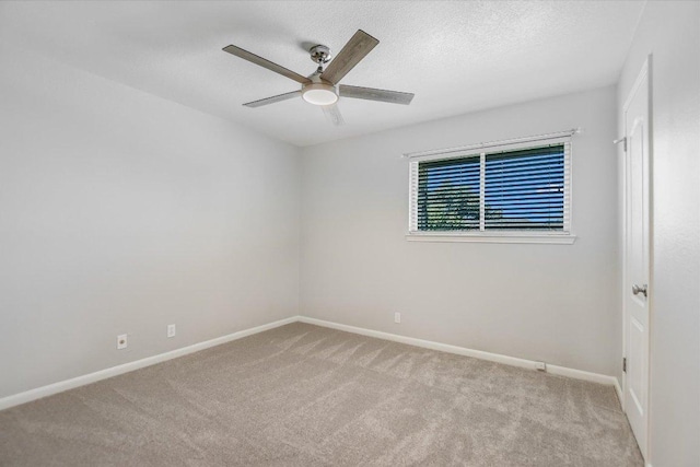 empty room featuring baseboards, a textured ceiling, ceiling fan, and carpet flooring