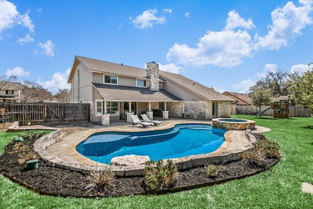 view of pool featuring a lawn, a gate, a pool with connected hot tub, a patio, and a fenced backyard