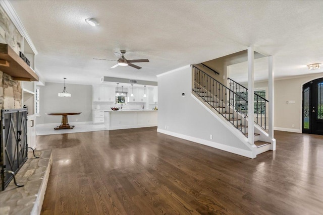 11402 Pencewood Dr, Austin, TX 78750 - unfurnished living room with ceiling fan, stairway, wood finished floors, a textured ceiling, and crown molding
