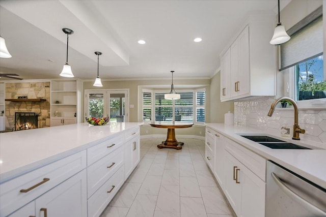 11402 Pencewood Dr, Austin, TX 78750 - kitchen with stainless steel dishwasher, light countertops, plenty of natural light, recessed lighting, and white cabinets