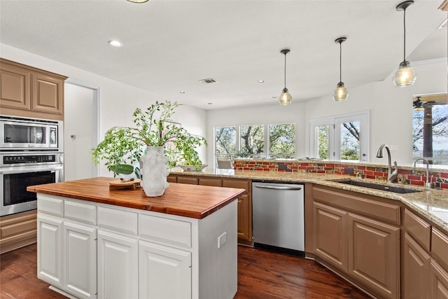 kitchen featuring visible vents, wooden counters, dark wood finished floors, a sink, and stainless steel appliances