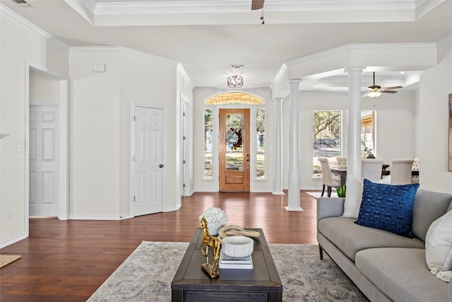 living room featuring a raised ceiling, decorative columns, wood finished floors, and ceiling fan