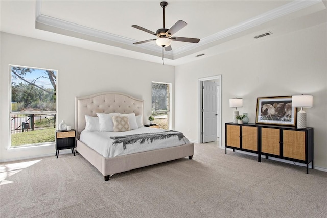 carpeted bedroom featuring visible vents, a raised ceiling, and ornamental molding