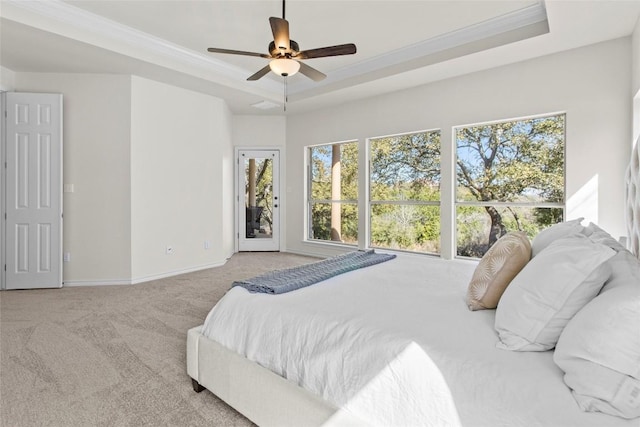 carpeted bedroom with a tray ceiling, access to outside, crown molding, and baseboards