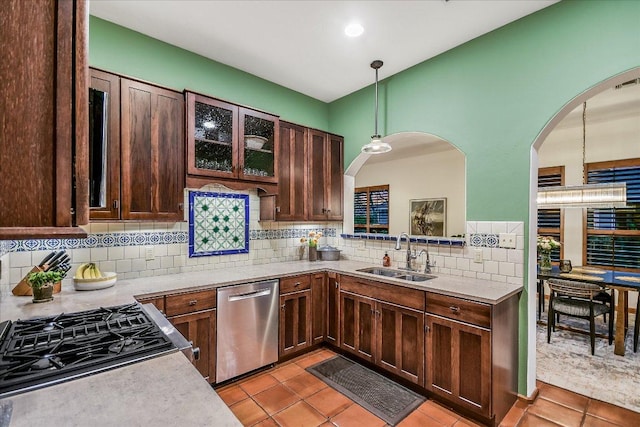 kitchen featuring a sink, stainless steel dishwasher, light tile patterned floors, and light countertops