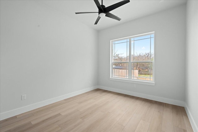 spare room with light wood-style flooring, a ceiling fan, and baseboards