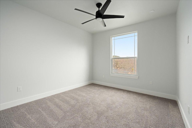 spare room featuring carpet flooring, a ceiling fan, and baseboards