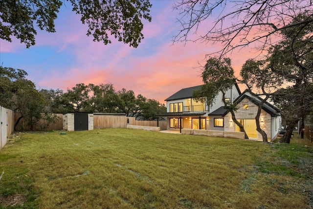 view of yard featuring a storage shed, a fenced backyard, an outdoor structure, and a patio