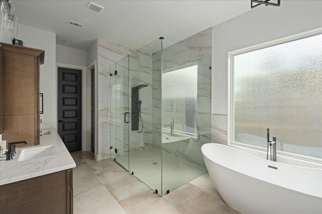 full bath featuring a marble finish shower, visible vents, a freestanding bath, and a sink