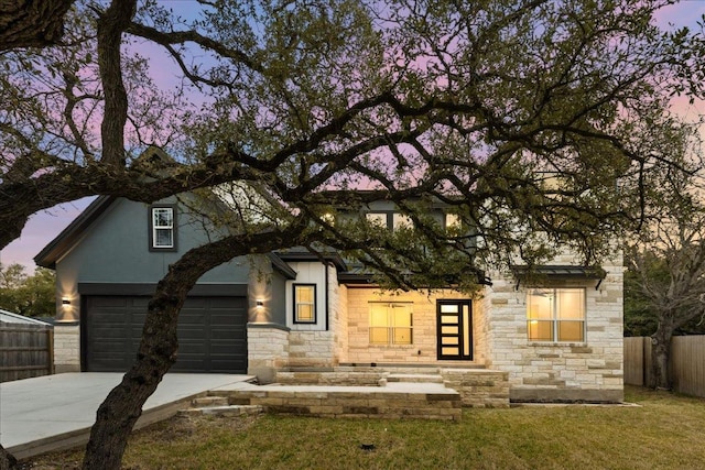 view of front of house featuring fence, concrete driveway, stucco siding, a lawn, and a garage