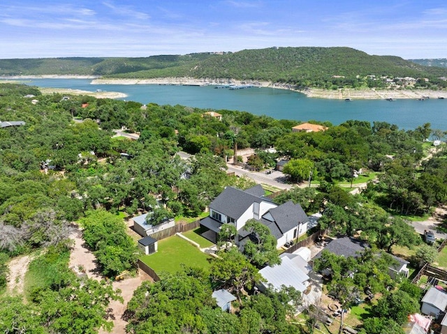 birds eye view of property featuring a forest view and a water view