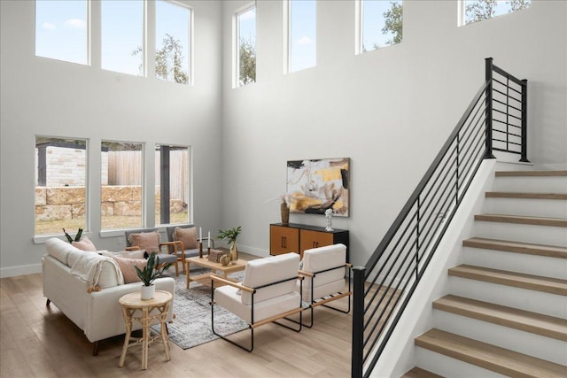 living room with a high ceiling, wood finished floors, and baseboards