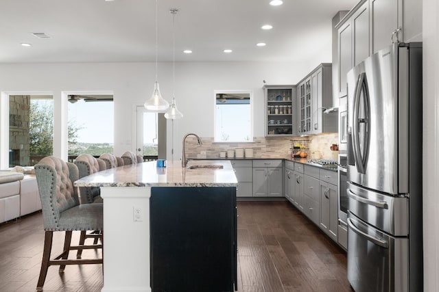 kitchen featuring a sink, gray cabinetry, a wealth of natural light, and stainless steel fridge with ice dispenser