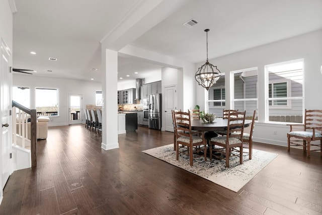 dining area featuring dark wood-type flooring, recessed lighting, visible vents, and a chandelier