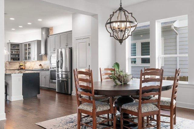 dining space with recessed lighting, a notable chandelier, and dark wood finished floors