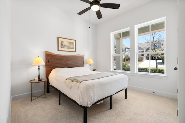 carpeted bedroom featuring baseboards and a ceiling fan