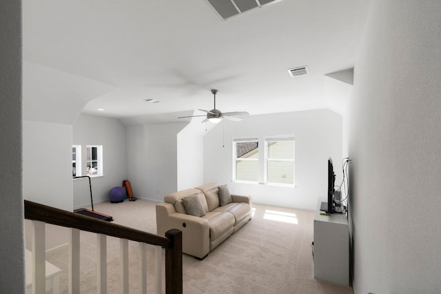 living area featuring visible vents, light colored carpet, a ceiling fan, and lofted ceiling