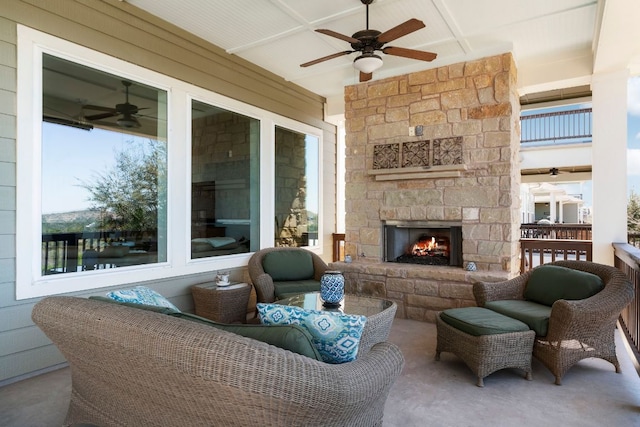 view of patio / terrace with an outdoor living space with a fireplace and a ceiling fan