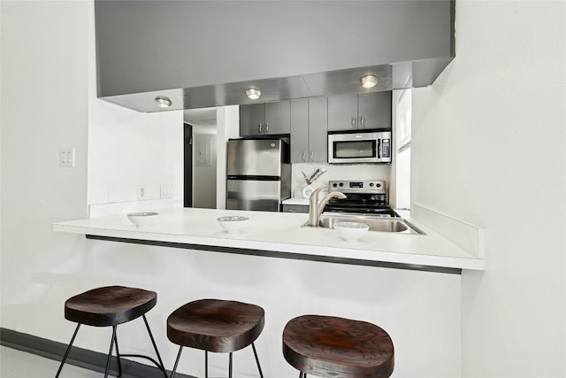300 Crockett St Unit 118, Austin, TX 78704 - kitchen featuring appliances with stainless steel finishes, a peninsula, a sink, and a kitchen breakfast bar
