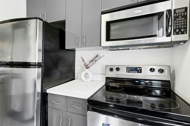 300 Crockett St Unit 118, Austin, TX 78704 - kitchen featuring appliances with stainless steel finishes, gray cabinets, and light countertops