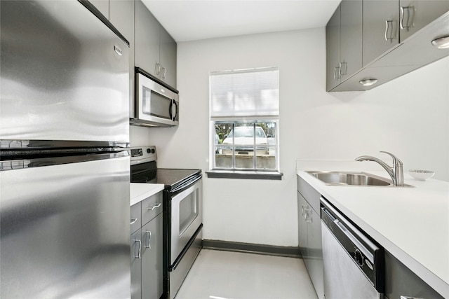 300 Crockett St Unit 118, Austin, TX 78704 - kitchen with stainless steel appliances, a sink, gray cabinets, light countertops, and baseboards