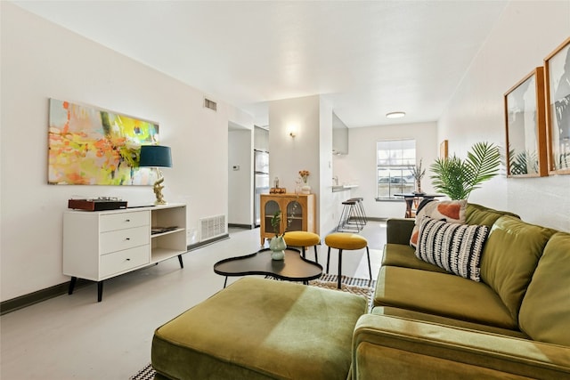 living room with baseboards, visible vents, and finished concrete floors