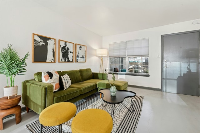 living room featuring baseboards and concrete flooring