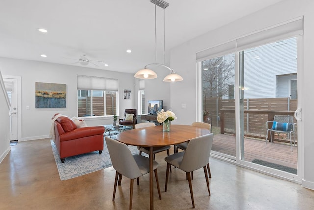 dining space with recessed lighting, baseboards, concrete flooring, and a healthy amount of sunlight