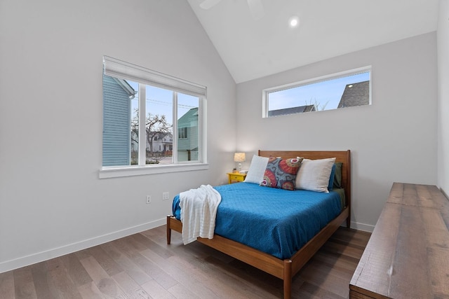 bedroom featuring multiple windows, baseboards, and wood finished floors