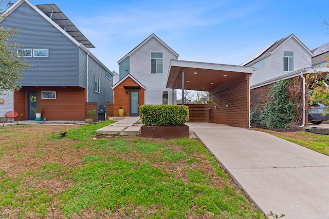 contemporary home featuring an attached carport, driveway, and a front yard