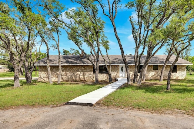 view of front of house with stone siding and a front lawn