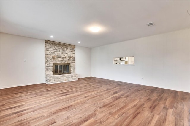 unfurnished living room with visible vents, recessed lighting, a fireplace, and wood finished floors