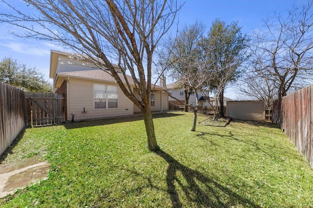 view of yard featuring an outdoor structure, a gate, a storage unit, and a fenced backyard