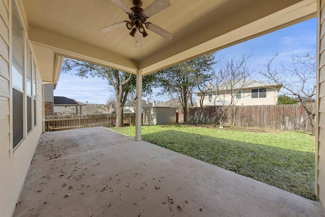 view of patio with a storage shed, an outdoor structure, a ceiling fan, and a fenced backyard