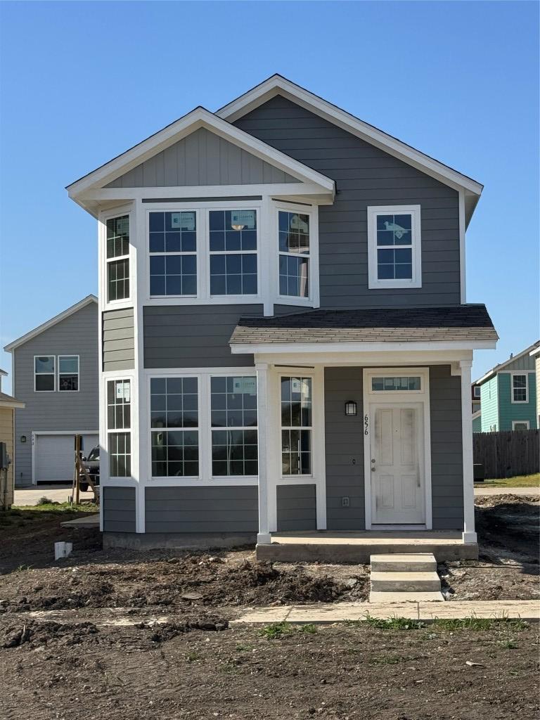 view of front facade with a porch, fence, and board and batten siding