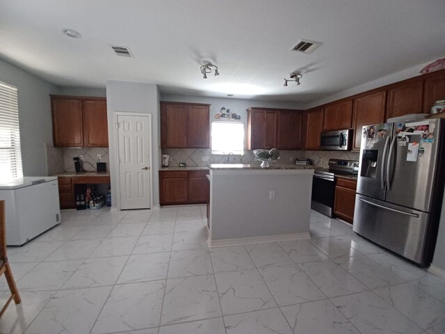 kitchen with stainless steel appliances, backsplash, marble finish floor, and visible vents