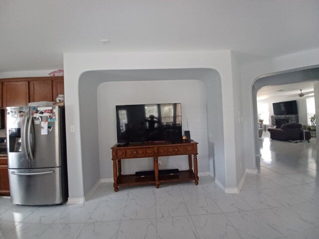 interior space with arched walkways, marble finish floor, and baseboards