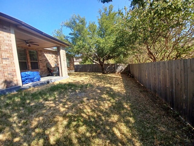 view of yard featuring a fenced backyard, a patio, and ceiling fan