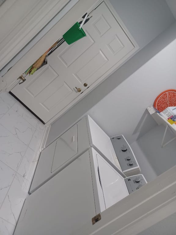 laundry area featuring marble finish floor, laundry area, and washing machine and clothes dryer