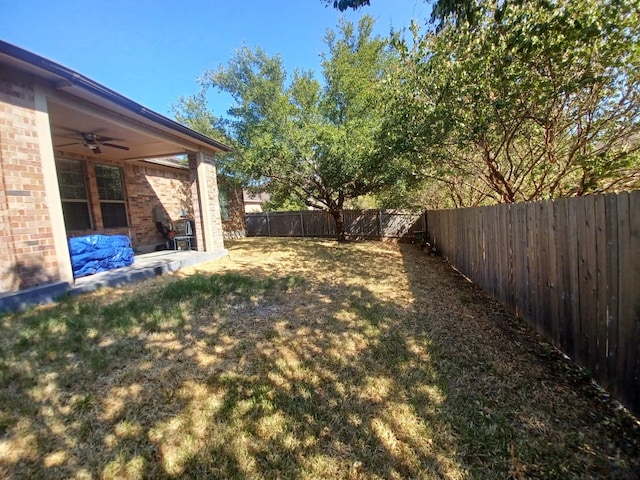 view of yard with a fenced backyard, a patio, and ceiling fan