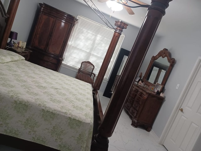 bedroom featuring a ceiling fan, marble finish floor, and baseboards