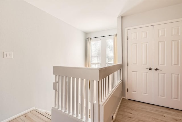 unfurnished bedroom featuring a closet, baseboards, and wood finished floors