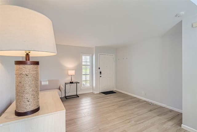 foyer featuring baseboards and light wood-style flooring