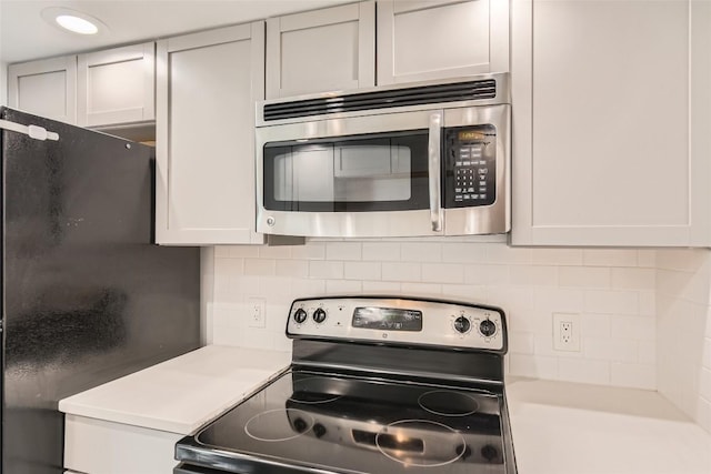 kitchen with stainless steel appliances, backsplash, and light countertops