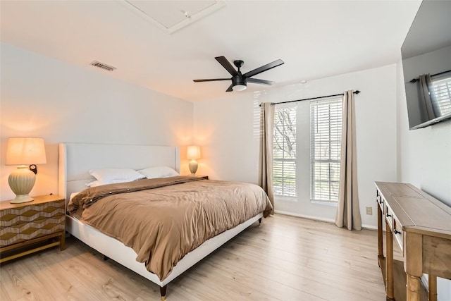 bedroom with baseboards, visible vents, light wood finished floors, and ceiling fan