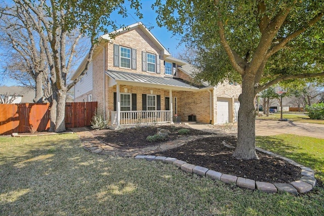 traditional-style home featuring a standing seam roof, fence, covered porch, metal roof, and brick siding