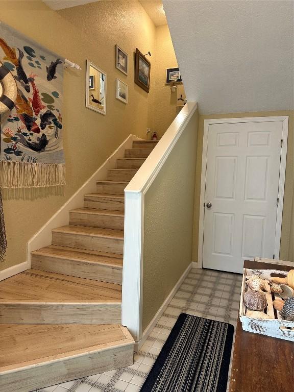 stairway featuring tile patterned floors and baseboards