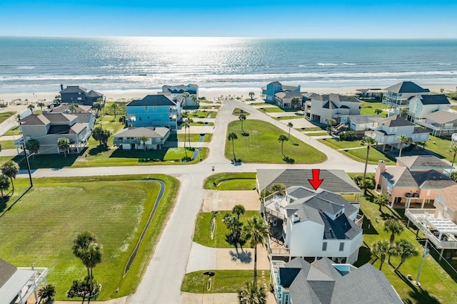 drone / aerial view featuring a residential view, a beach view, and a water view