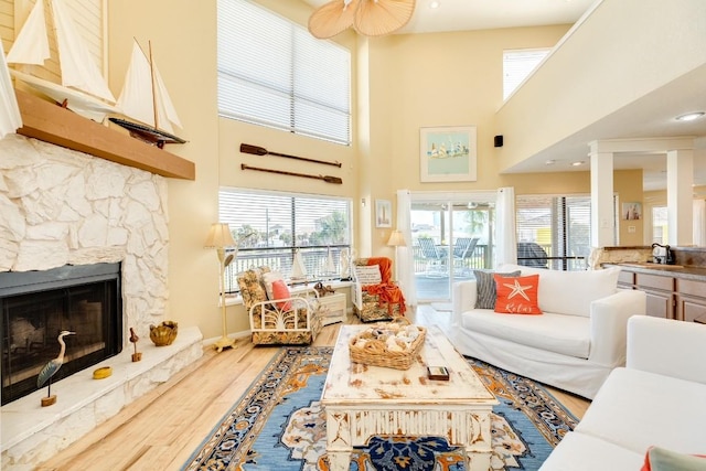 living area featuring a fireplace, a high ceiling, and wood finished floors